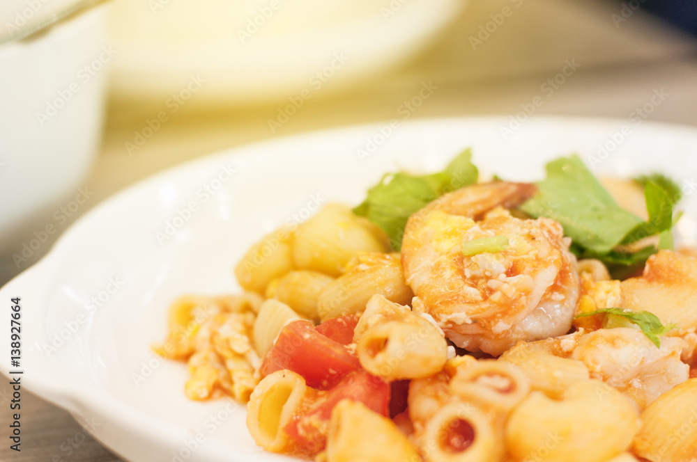 Shrimp macaroni in white plate with light flare. Shrimp macaroni in white plate with light flare.