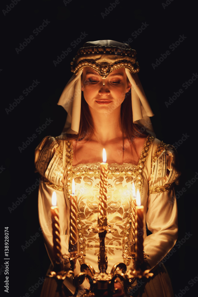 Darkness envelopes gorgeous princes with candleholder in her arms