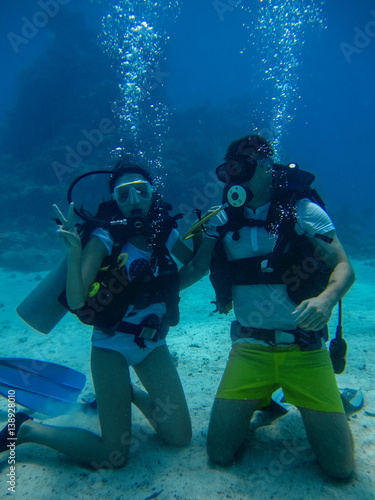 Young couple on the seafloor while diving