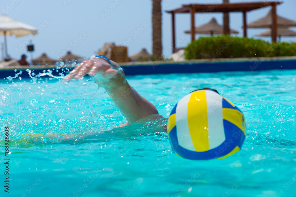 Man swimming near ball in a pool
