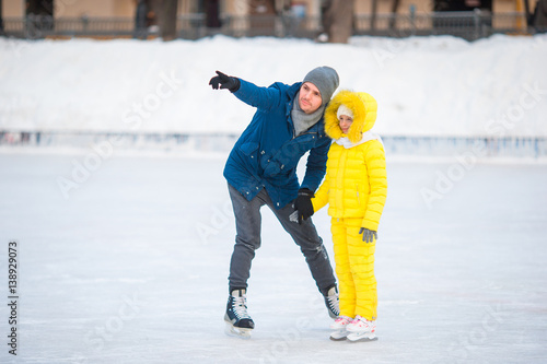 Family have fun on skating rink outdoors