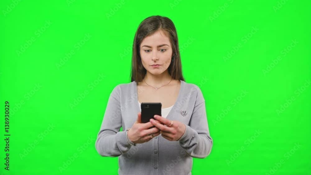 Woman receiving bad news on her phone slow motion on green screen background. Woman receiving bad news on her phone slow motion on green screen background.