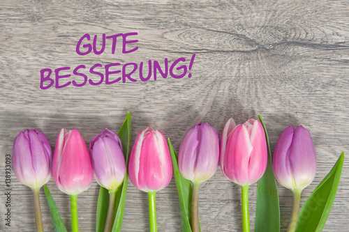 Fototapeta Naklejka Na Ścianę i Meble -  Tulpen auf Holzhintergrund: Gute Besserung!