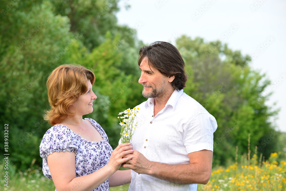 Fototapeta premium Happy middle-aged couple on nature in summer