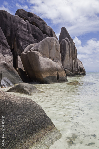 Unique granite rocks on the Anse Source d'Agrent beach on the shore of the calm Indian ocean on La Digue island, Seychelles