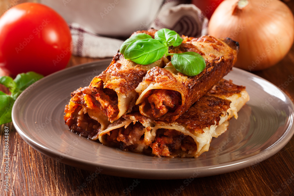 Naklejka premium Baked cannelloni with minced meat and bechamel sauce on a plate