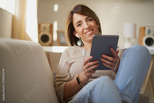woman reading / listening music using tablet at home