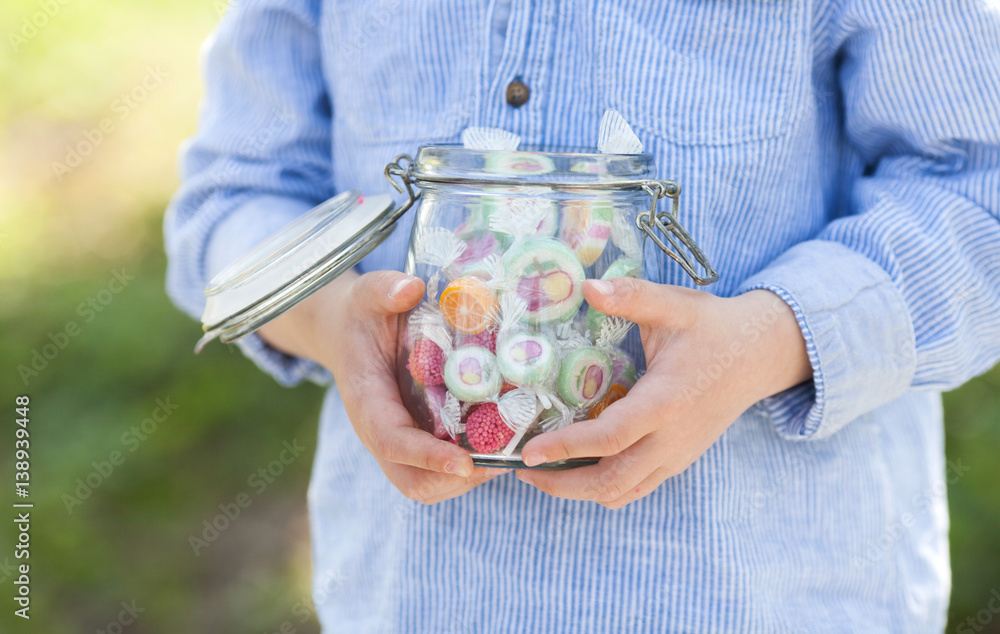 child holding a jar full of sweets
