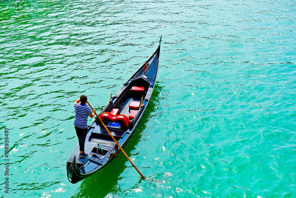Fototapeta premium Gondola punted by a gondolier on the Grand Canal in Venice. 