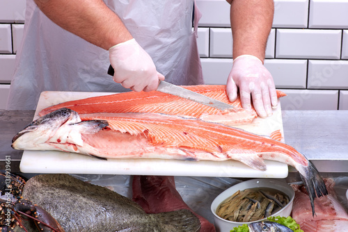 Man filleting a salmon in fish store