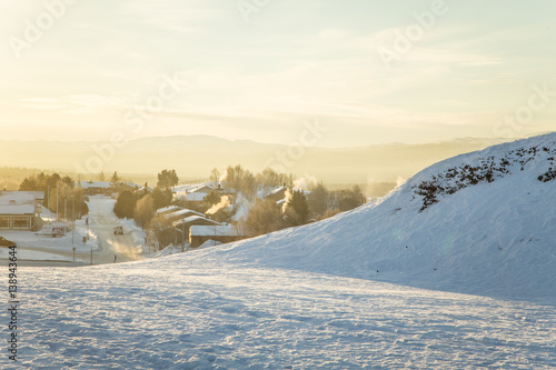 A beautiful morning panorama of a small Norwegian town during sunrise with a flares and warm look