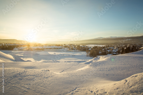A beautiful morning panorama of a small Norwegian town during sunrise with a flares and warm look © dachux21