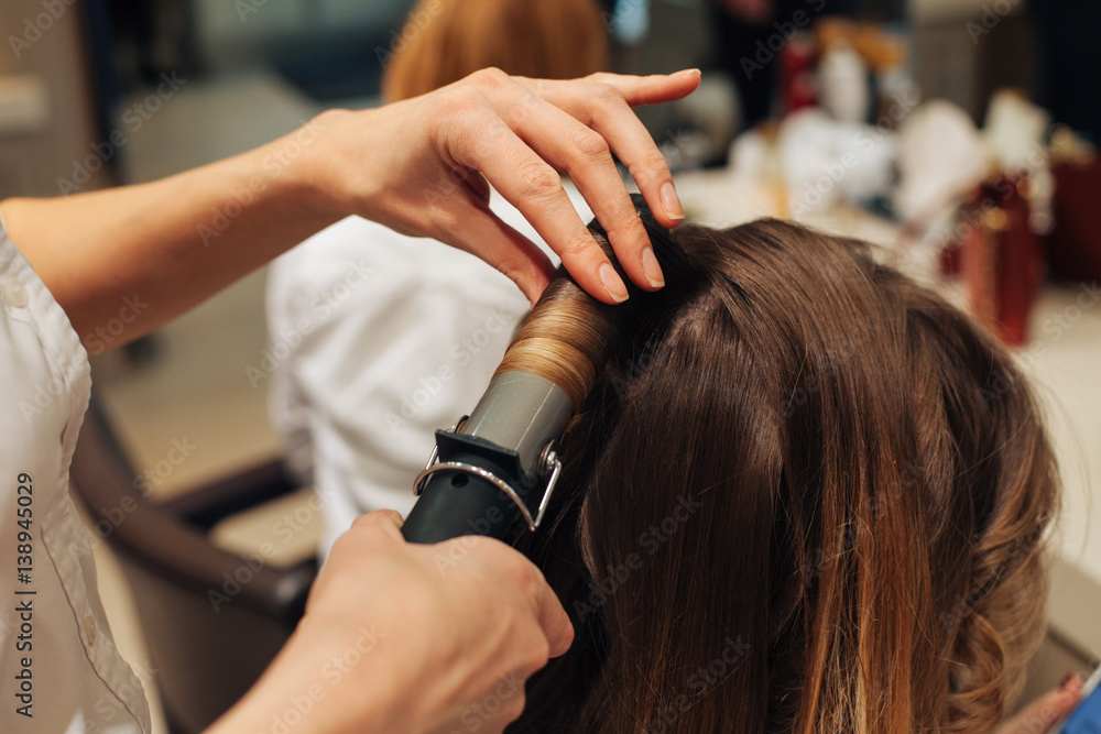 Fototapeta premium master in a beauty salon girl doing hairstyle