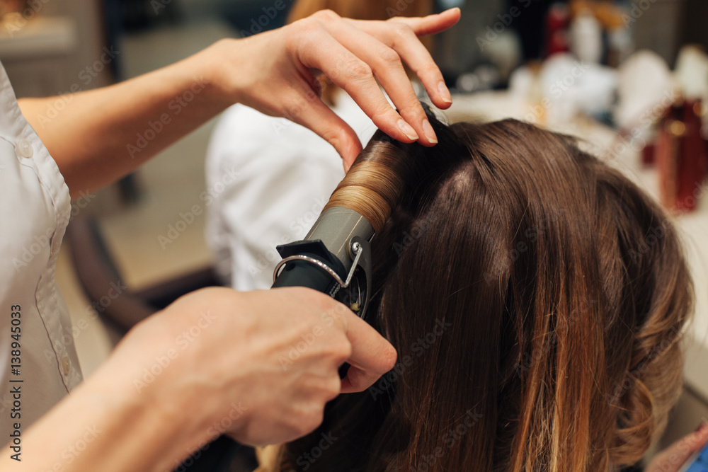 Fototapeta premium master in a beauty salon girl doing hairstyle