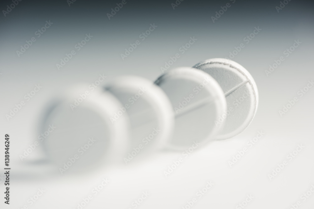 Close-up view of round white medical tablets in row, medicine and healthcare concept Close-up view of round white medical tablets in row, medicine and healthcare concept