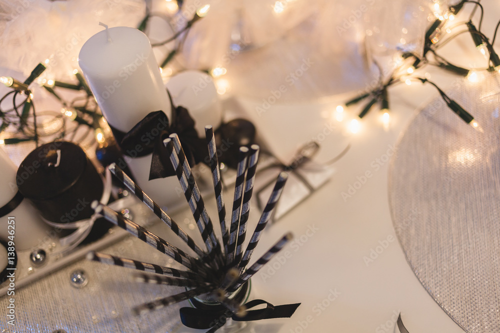 Holiday table decoration with white candles and bulb garland