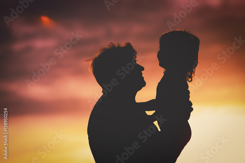 Silhouette of happy grandmother and granddaughter at sunset