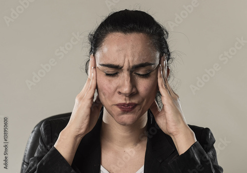 business woman in office suit suffering migraine pain and strong headache