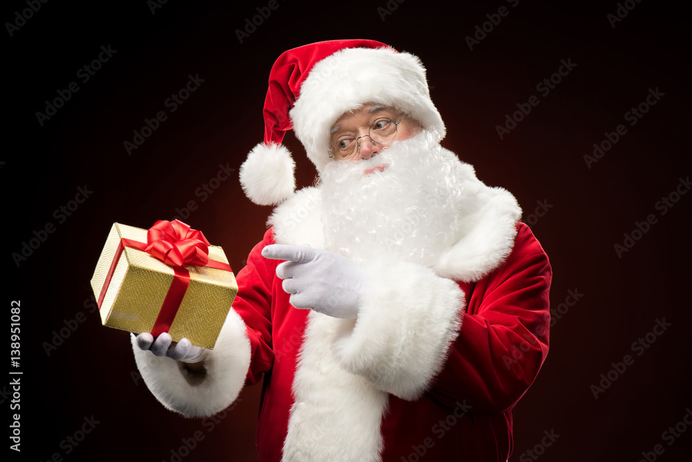 Santa Claus pointing on gift box