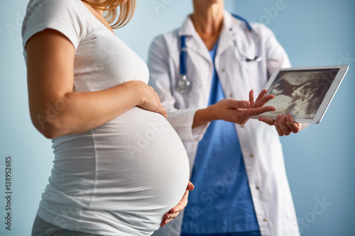 Fotografie, Obraz Mid-section image of unrecognizable female doctor explaining ultrasound scan res
