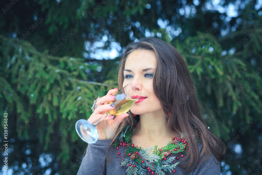 Beautiful brunette girl with glass of champagne outdoors on winter evening Beautiful brunette girl with glass of champagne outdoors on winter evening