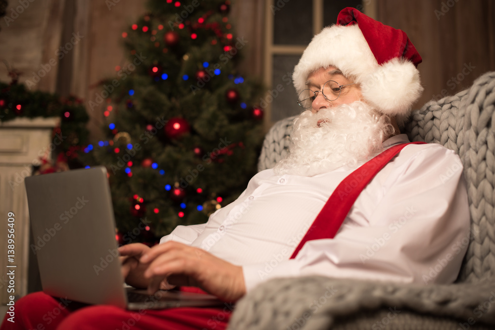 Santa Claus using laptop Santa Claus using laptop