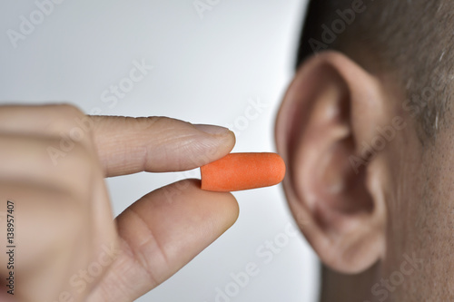 Foto man putting on an earplug