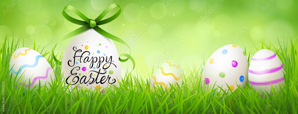 painted easter eggs with, lettering and curled bow in the meadow - Happy Easter