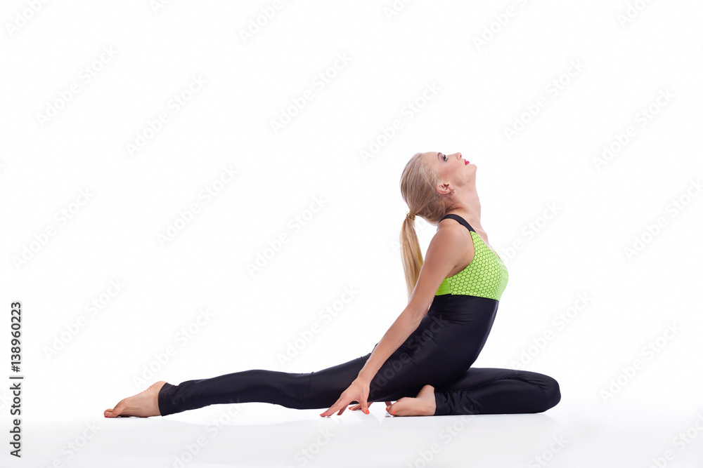 Gorgeous young woman practicing yoga sitting on the floor 