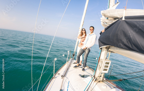 Young couple in love on sail boat having fun with champagne flute glasses - Happy exclusive travel concept on sailboat tour - Boyfriend and girlfriend on luxury cruise - Sunny afternoon color tones © Mirko Vitali