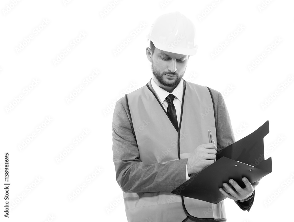 Male architect in a safety west and a hardhat writing on his cli Male architect in a safety west and a hardhat writing on his cli