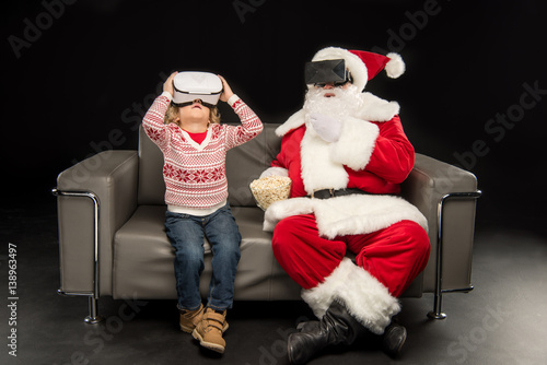 Kid and Santa Claus in virtual reality headsets