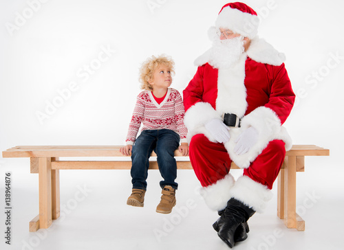 Santa Claus with kid sitting on bench