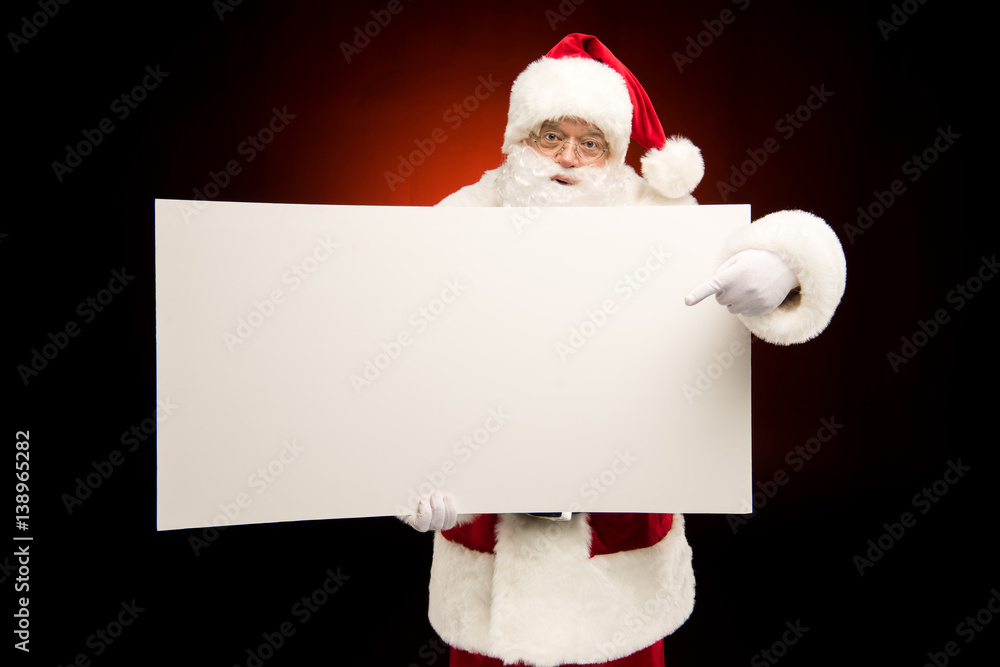 Santa Claus pointing on blank card Santa Claus pointing on blank card