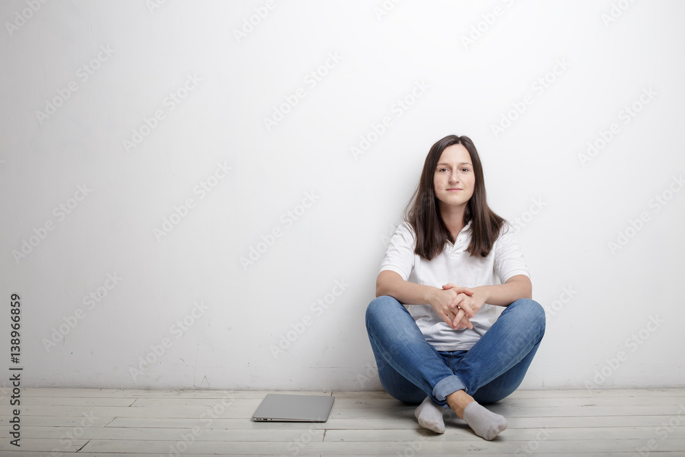 beautiful woman finished work contentedly sitting against the wall on the floor is closed notebook beautiful woman finished work contentedly sitting against the wall on the floor is closed notebook