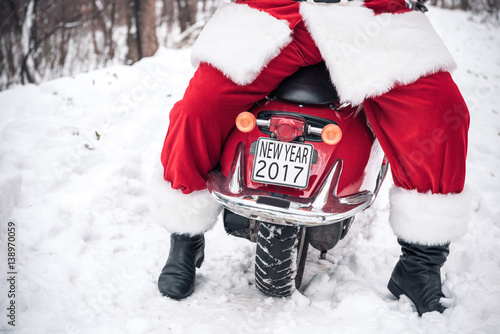 Santa Claus sitting on red scooter