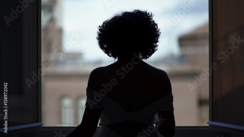 silhouette of sexy dancing woman at the window photo