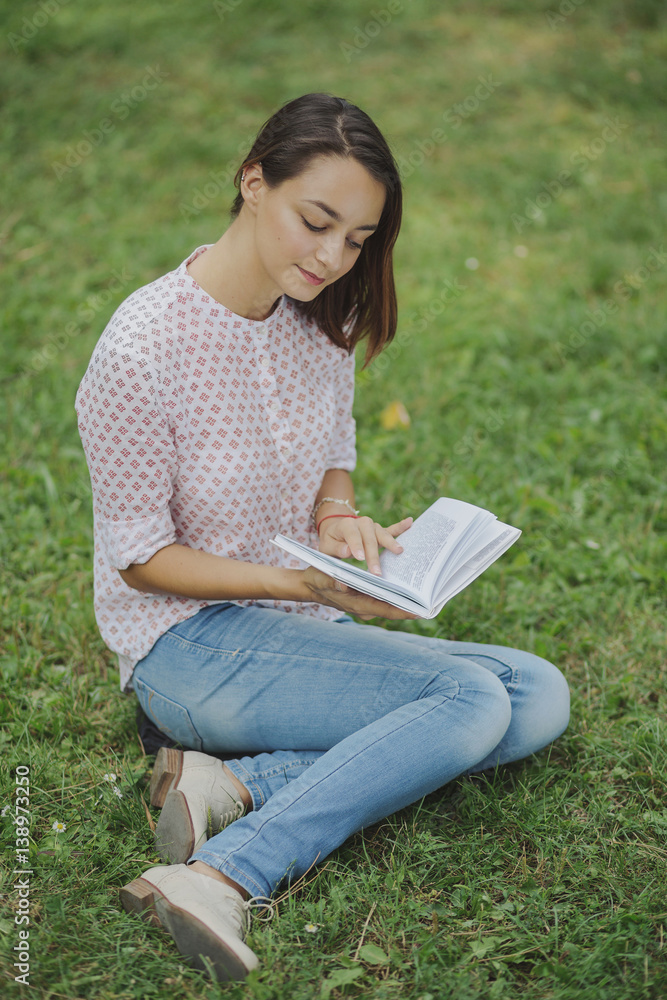 Obraz premium Cute young woman reading the book
