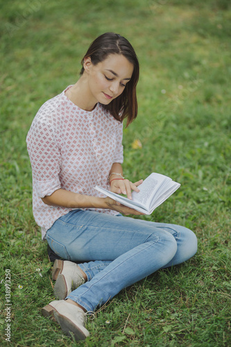 Cute young woman reading the book