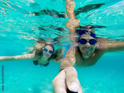 Making under water photo selfie stick selfie couple diving snorkeling.