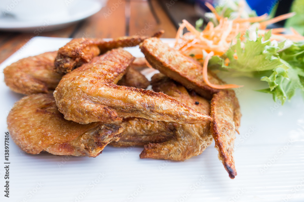 Chichen wing fried with salad in white dish on wooden table with copyspace ,flat lay ,selective focus Chichen wing fried with salad in white dish on wooden table with copyspace ,flat lay ,selective focus