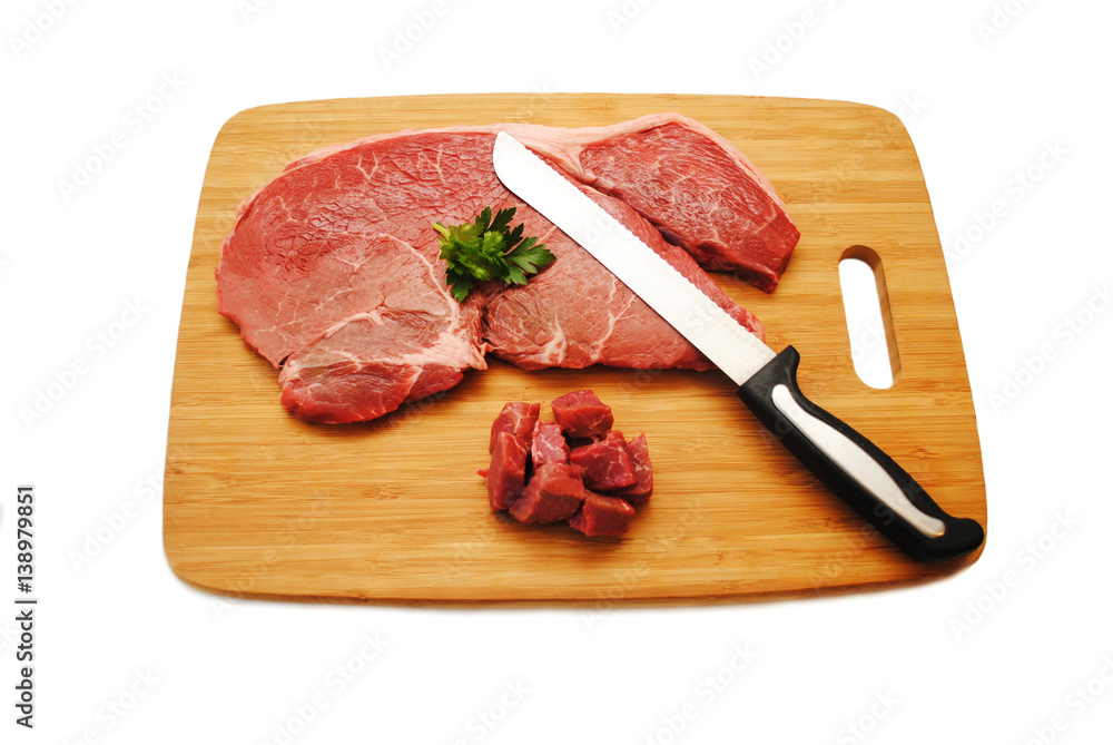 Cutting a Raw Steak on a Wooden Cutting Board Cutting a Raw Steak on a Wooden Cutting Board
