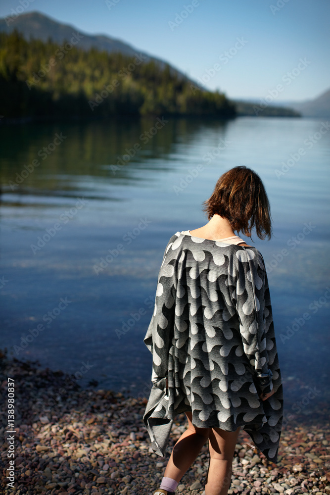 Rear view of a woman walking towards lake Rear view of a woman walking towards lake