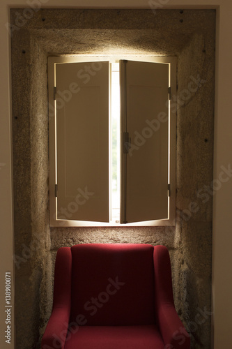 Red chair under shuttered window