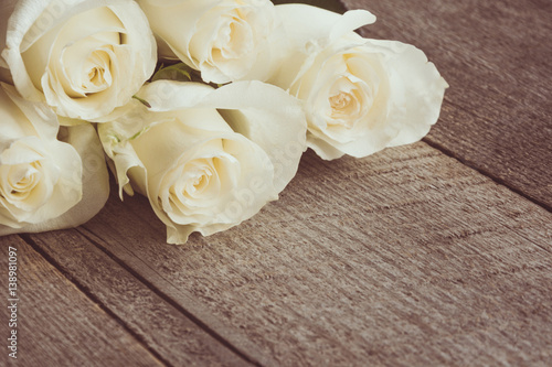 Soft full blown white roses as a neutral background on wooden board. Selective focus. Toned image. © svetlana_cherruty