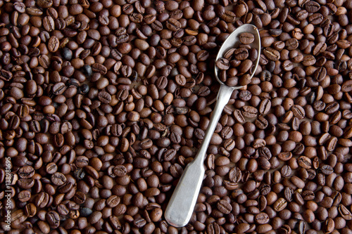 Metal teaspoon and coffee beans
