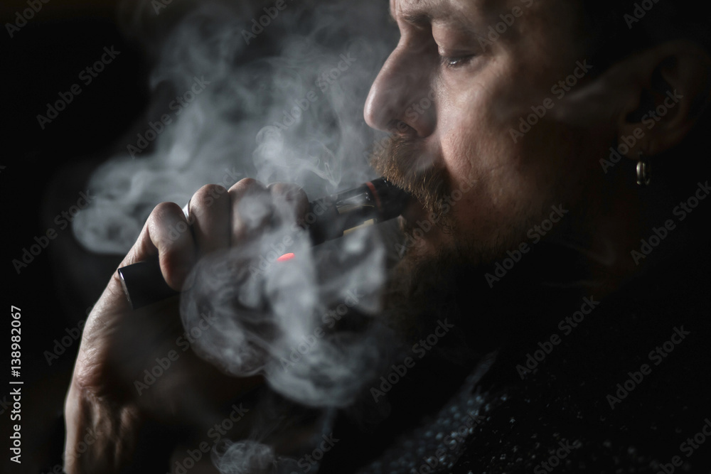 Man portrait smoking an electronic cigarette
