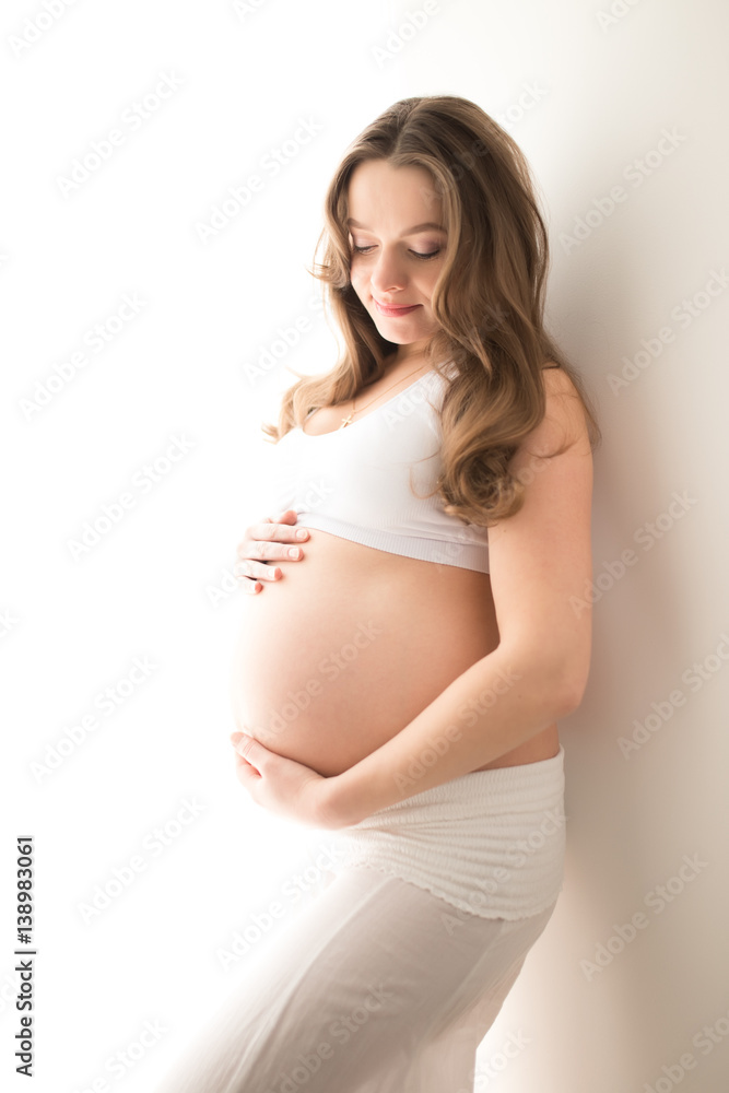 Pregnant woman with big tummy on a white background Pregnant woman with big tummy on a white background
