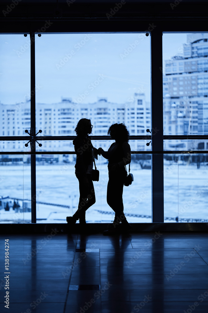 Two girls at the window backlit in a shopping center minsk Two girls at the window backlit in a shopping center minsk
