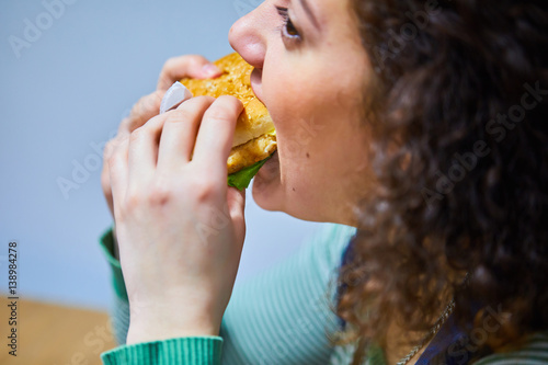 fat girl eating a hamburger